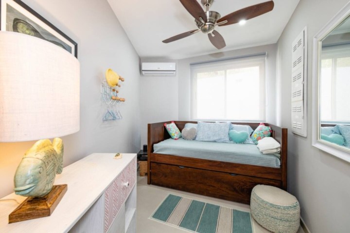 a bedroom area with a sink and a window