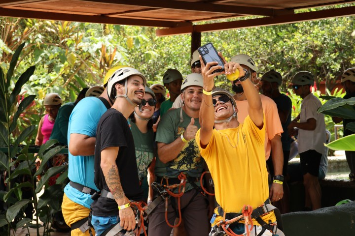 Group of people in helmets taking a selfie in an outdoor setting.