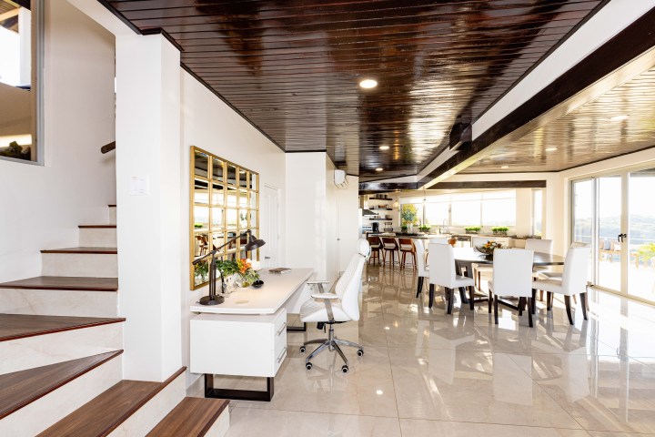 Modern open-plan living space with office, dining, and kitchen areas.