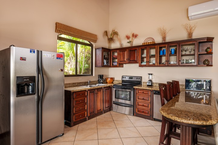 Modern kitchen with stainless appliances, wooden cabinets, and granite countertops.