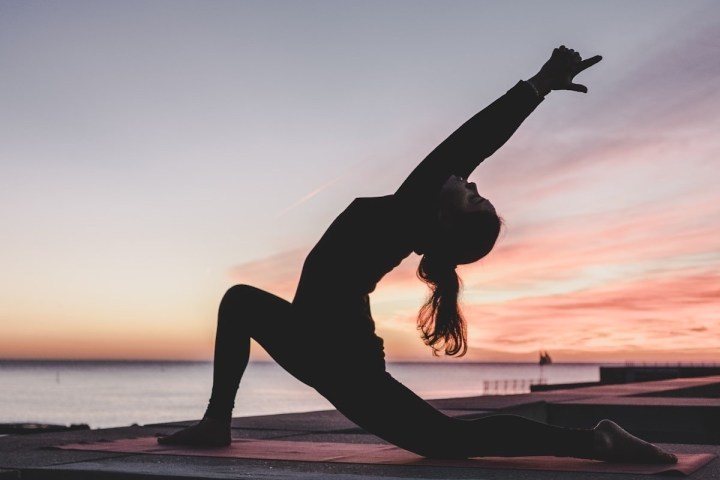a person with long hair and a sunset in the background