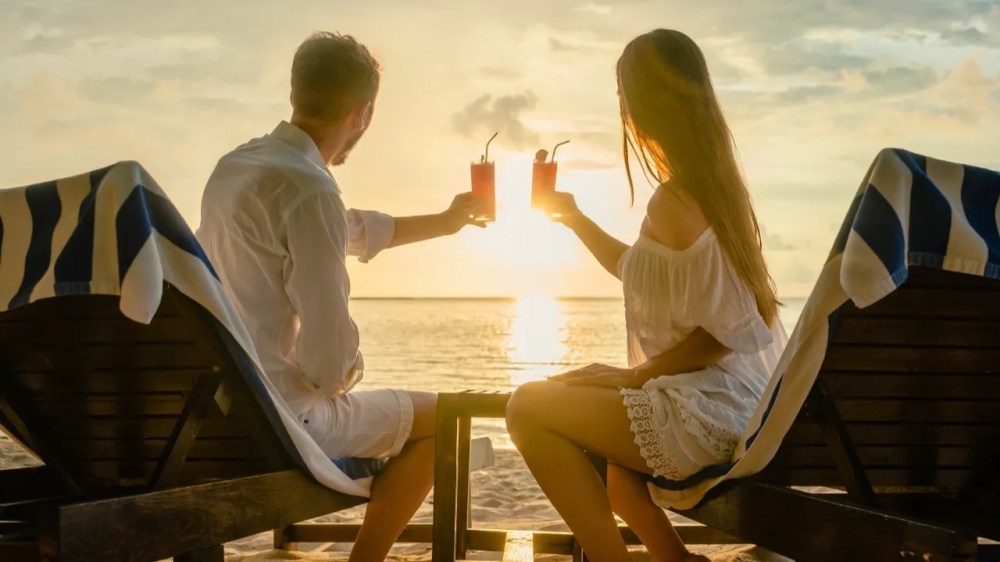 a man and a woman sitting at a beach