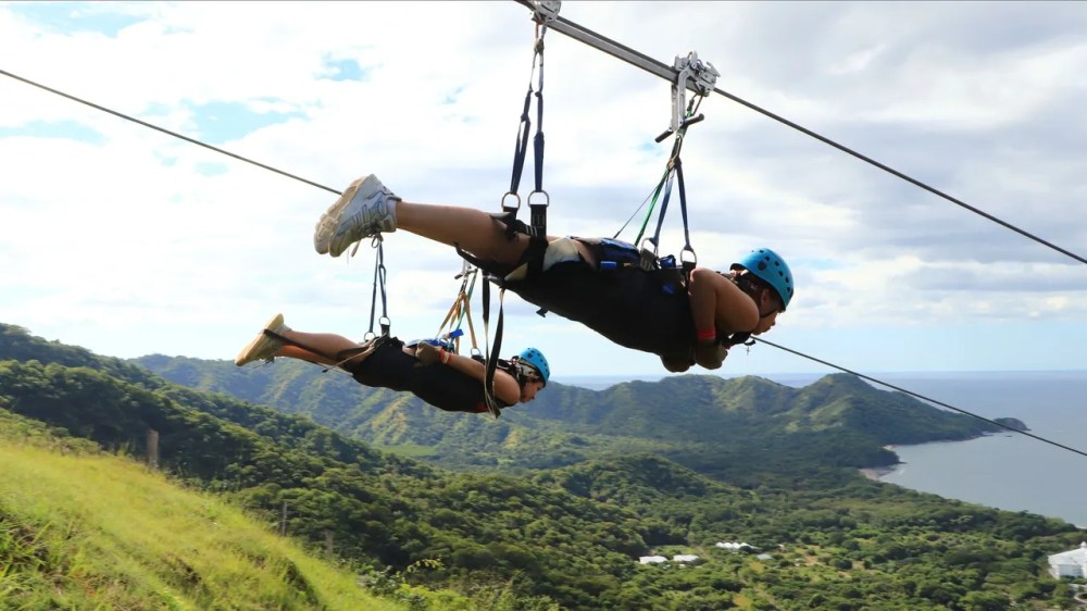 a person in a swing with a mountain in the background