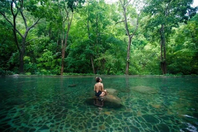 a man standing next to a river