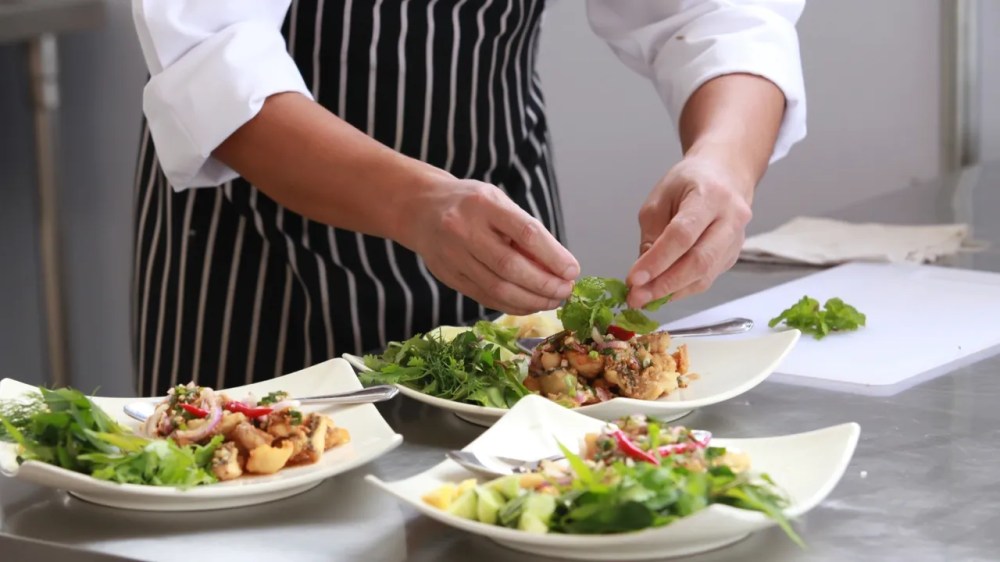 a woman sitting at a table with a plate of food with broccoli