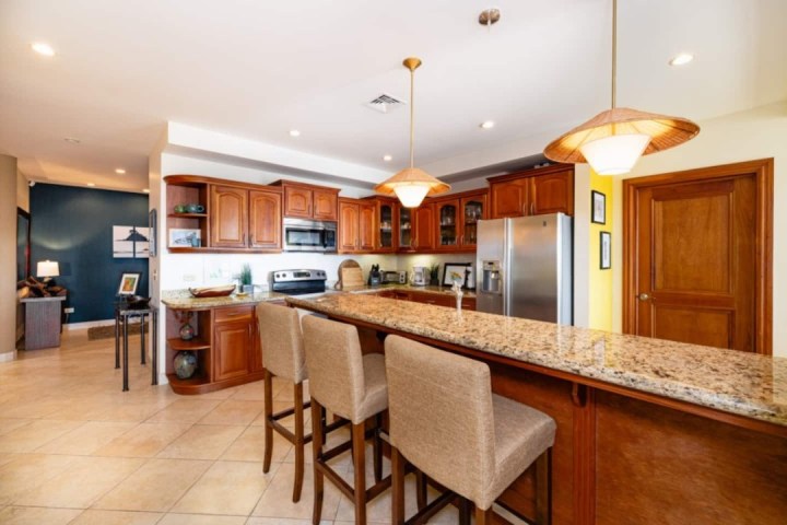 Spacious kitchen with wooden cabinets, granite countertops, and pendant lighting.