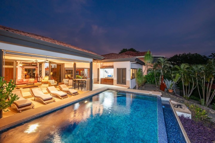 a house with a pool in front of a building