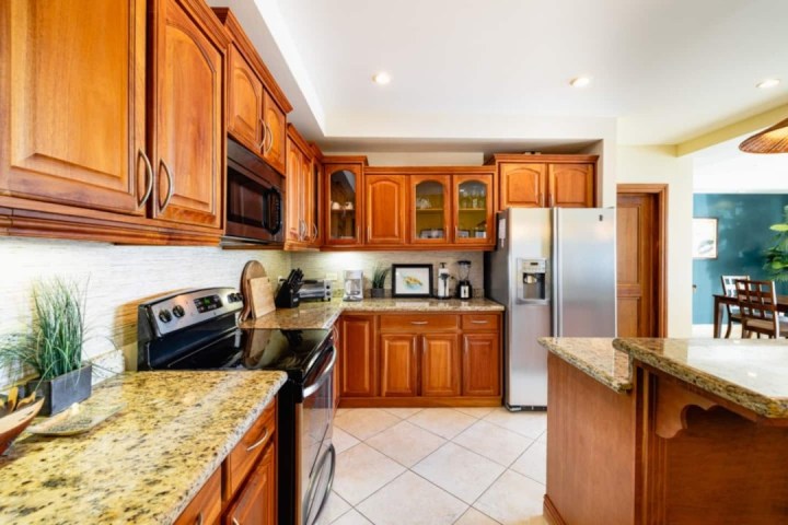 Modern kitchen with wooden cabinets, granite countertops, and stainless steel appliances.