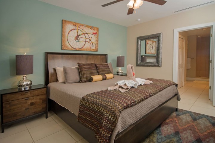 Bedroom with a large bed, bicycle artwork, and folded towel swans on the bed.