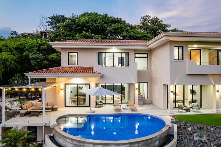 a house with a pool in front of a building
