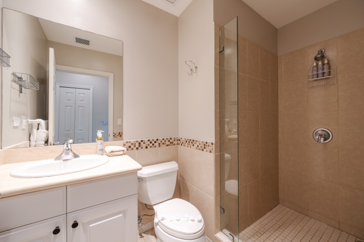 Modern bathroom with a sink, toilet, and glass-enclosed shower.