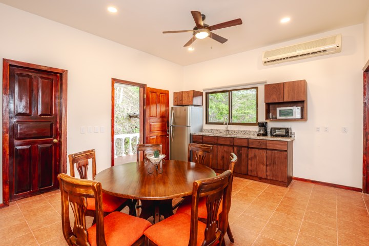 Cozy kitchen with wooden cabinets, round dining table, and a ceiling fan.