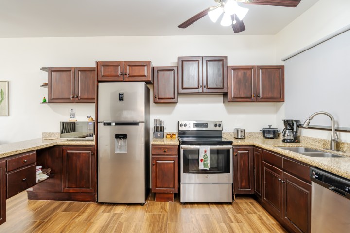 Modern kitchen with stainless steel appliances and dark wood cabinets.