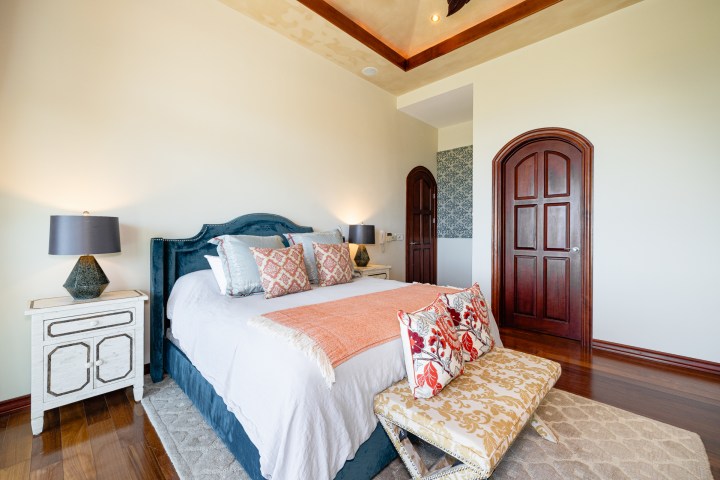 Cozy bedroom with a large bed, decorative pillows, and wooden doors.