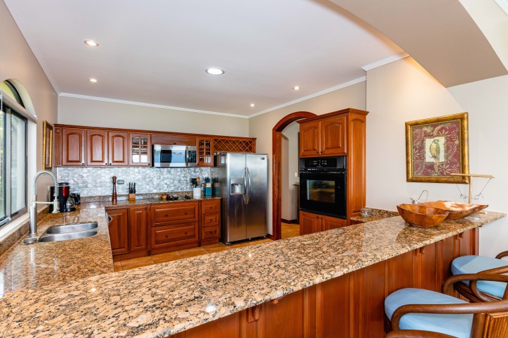Spacious kitchen with granite countertops, wooden cabinets, and stainless steel appliances.