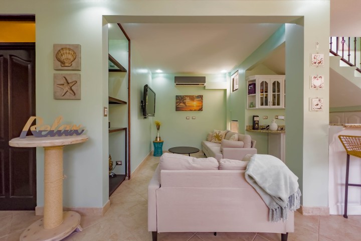 Cozy living room with pastel colors, plush sofas, and ‘Relax’ decor theme.