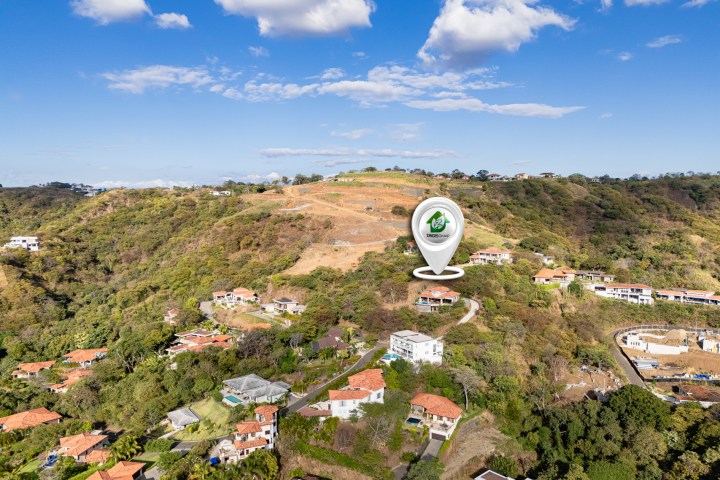 Aerial view of hillside houses with a location pin over one.