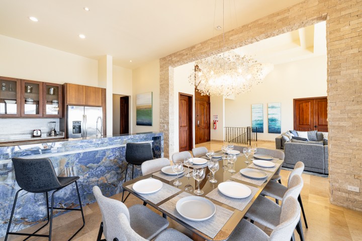 Modern kitchen and dining area with stone accents and a chandelier.