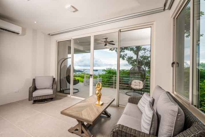 Modern living room with sliding doors to a balcony and outdoor view.