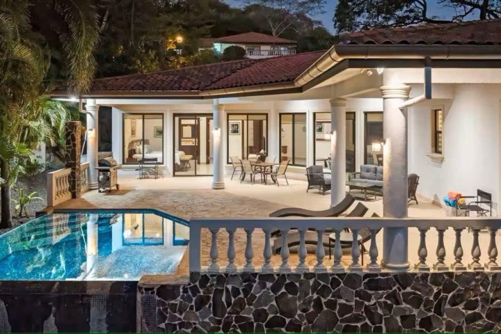 a house with a pool in front of a building