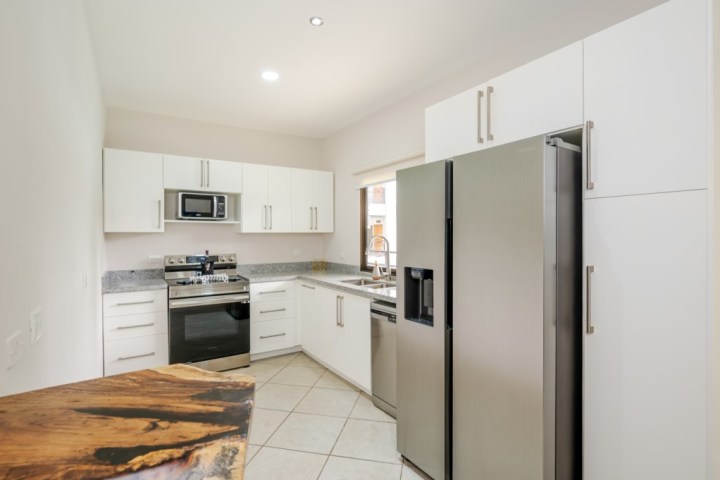 Modern kitchen with white cabinets, stainless steel appliances, and granite countertops.