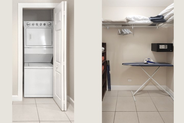 Laundry nook with stackable washer-dryer, ironing board, and shelf with linens.