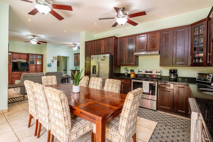 Kitchen and dining area with wooden cabinets, table, and stainless steel appliances.