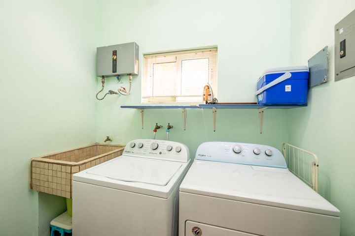 Laundry room with washer, dryer, utility sink, and small window.