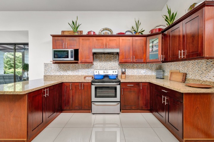 Modern kitchen with wooden cabinets, beige countertops, and stainless steel appliances.