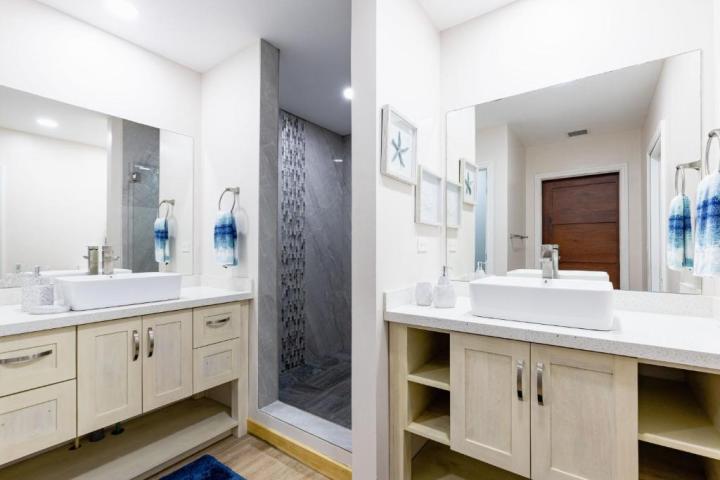 Modern bathroom with dual sinks, mirrors, and walk-in shower.