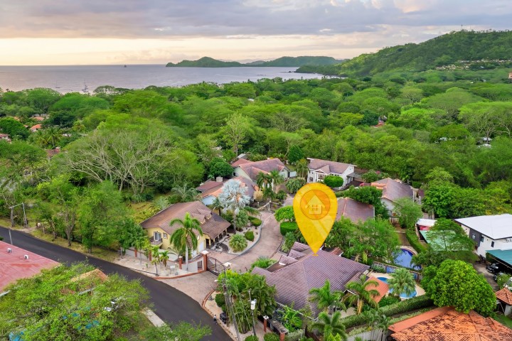 Aerial view of a coastal village with lush greenery and a sea view.