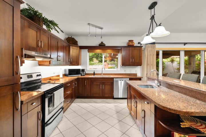 Spacious kitchen with wooden cabinets, granite countertops, and modern appliances.