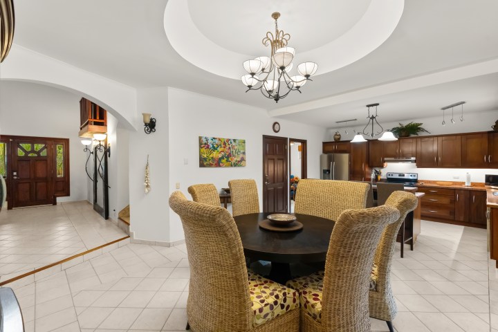 Spacious kitchen and dining area with wicker chairs and a round table.