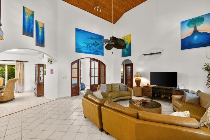 Spacious living room with circular sofa, TV, and vibrant wall art.