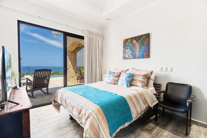 Bright bedroom with ocean view and outdoor patio.