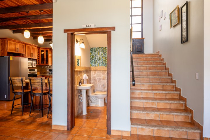 Interior with kitchen, stairs, and small bathroom.
