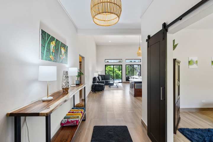 Modern hallway with wooden decor, leading to a bright living room.