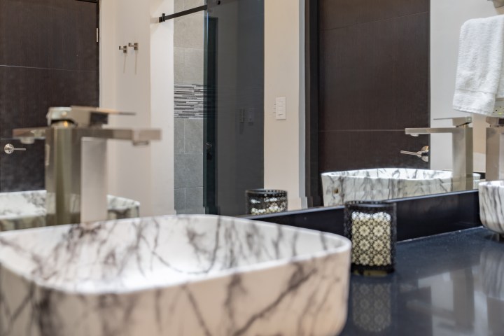 Modern bathroom with marble sink, black countertop, and towel on a rack.