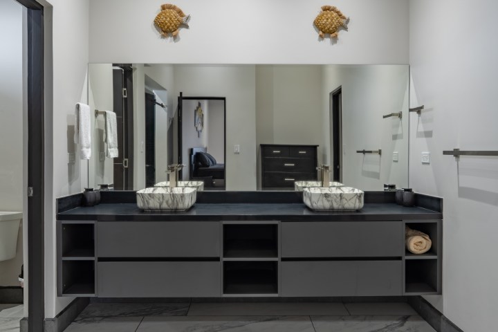 Modern bathroom with double sinks and large mirror.