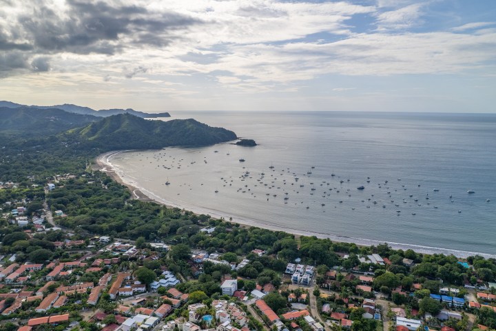 Aerial view of a coastal town with a bay and boats on the water.