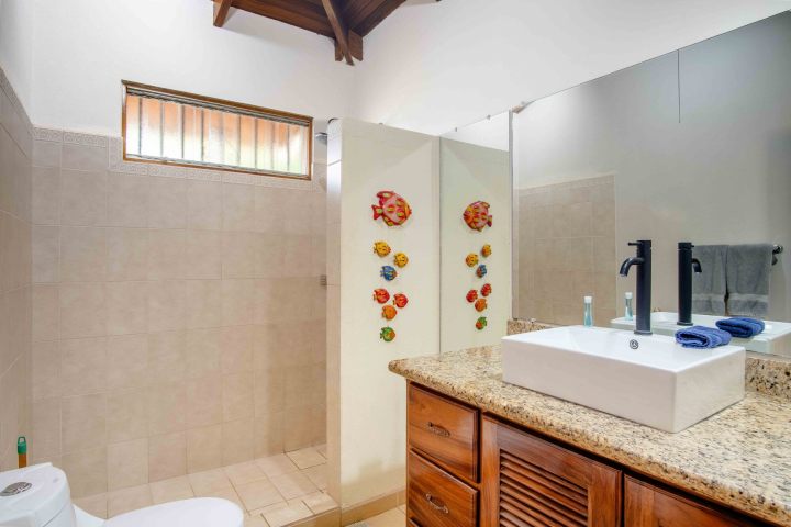 Bathroom with granite countertop, rectangular sink, and fish wall decor.